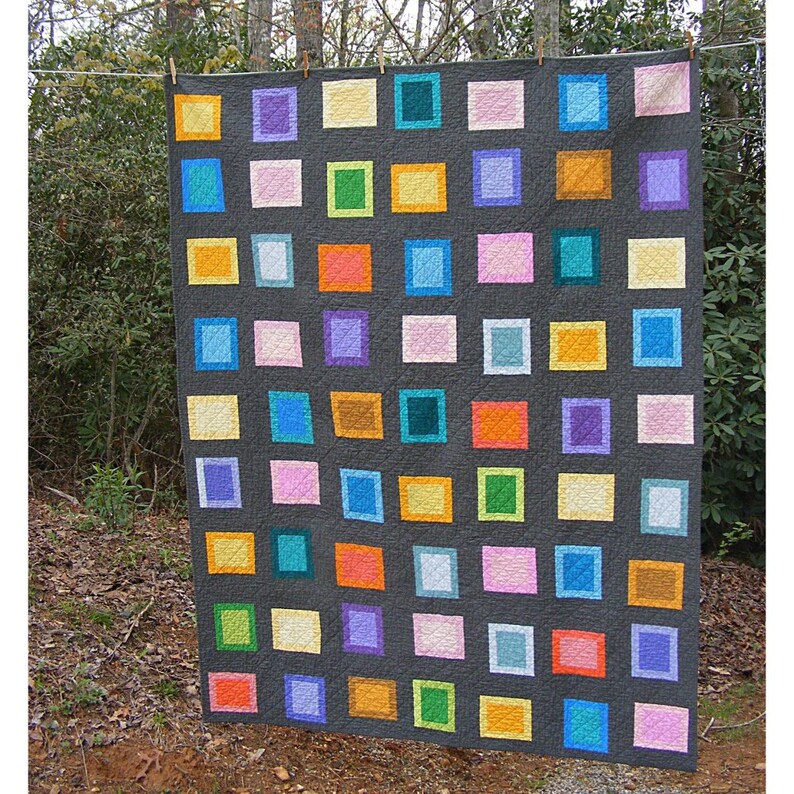 May include: A colorful quilt with a gray background and squares of various colors, including pink, orange, yellow, green, blue, and purple.