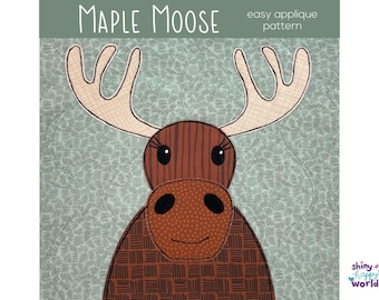 Op de afbeelding: Een stoffen applicatiepatroon met een bruine eland met een gestreepte kop, een gespikkelde snuit en beige geruit gewei. De tekst luidt Maple Moose easy applique pattern. De achtergrond is een lichtgroene stof met een donkergroene bladprint.