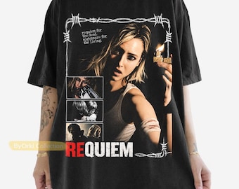 May include: A black short-sleeve t-shirt featuring a graphic print of a person holding a lit lighter. The design includes a barbed wire frame, smaller inset images, and the text "requiem for the dead nightmare for the living" and "REQUIEM".