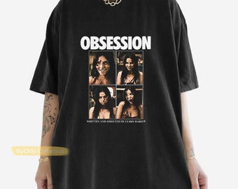 May include: A black short-sleeved t-shirt featuring the white text OBSESSION at the top. Below the text is a grid of four photographic images of a person with dark hair, with the text WRITTEN AND DIRECTED BY CURRY BARKER at the bottom.