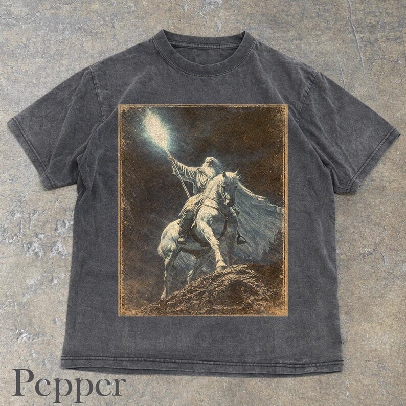 Pepper t-shirt featuring Gandalf on horseback with glowing staff in a vintage fantasy illustration, lord of the rings inspired wizard design, lotr fan art style graphic tee, magical wizard scene with detailed horse and mystical light, fantasy lover gift, wizard gift idea, lord of the ring shirt, gandalf shirt, fantasy aesthetic clothing, unisex streetwear tee, high quality print, perfect gift for lotr fans and magic lovers