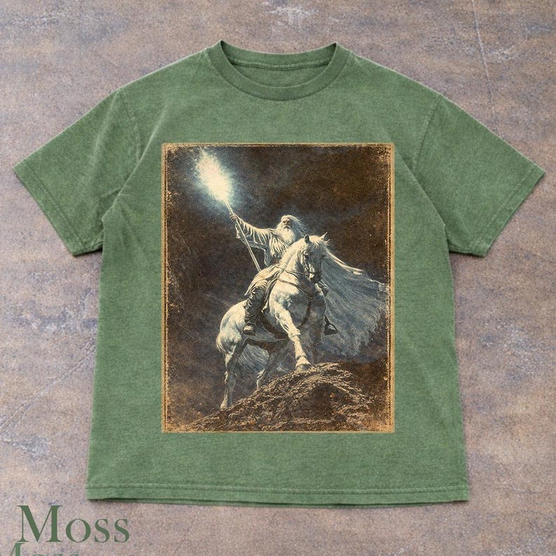 Moss t-shirt featuring Gandalf wizard riding a horse with glowing staff, Lord of the Rings Tolkien inspired Middle-earth fantasy design, vintage style wizard illustration artwork, epic adventure graphic tee for fantasy lovers and LOTR fans, wizard aesthetic clothing, unisex streetwear, mystical light and dark theme apparel, detailed character design, magical atmosphere shirt, perfect fantasy gift idea for him and her