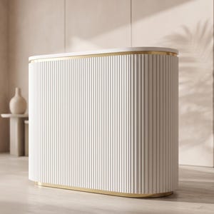 Peut inclure: Un comptoir d'accueil incurvé doté d'un extérieur blanc cannelé avec des rainures verticales. L'unité est rehaussée d'une fine bordure en métal doré sur les bords supérieur et inférieur, et possède une surface de comptoir blanche lisse et plate.