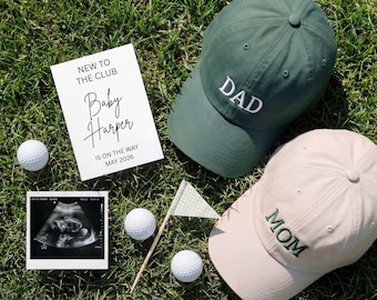 Puede incluir: Gorras de béisbol verdes y beige con "DAD" y "MOM" bordados, pelotas de golf, una ecografía de bebé y una tarjeta que dice "NEW TO THE CLUB Baby Harper IS ON THE WAY MAY 2026".