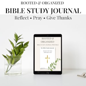 May include: A black tablet displays a Bible study journal with the text "ROOTED & ORGANIZED" and "BIBLE STUDY JOURNAL." The journal cover features a gold cross and the words "Reflect, Pray, Give Thanks." A glass vase with green leaves is on the left.