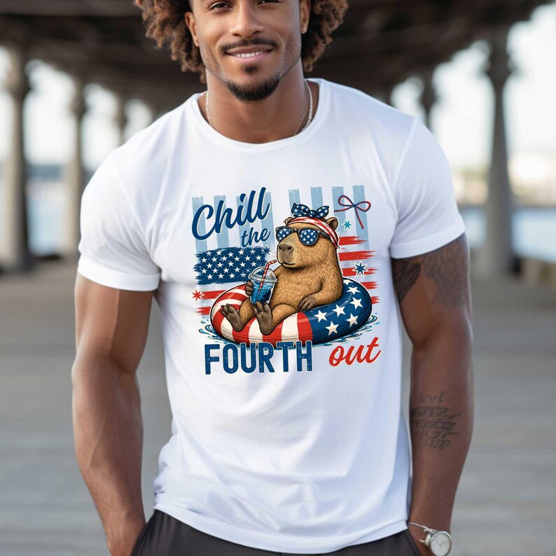 May include: White t-shirt with a patriotic design featuring a cartoon capybara wearing sunglasses and a headband, floating on a red, white, and blue inner tube. The shirt has the text "Chill the Fourth out".
