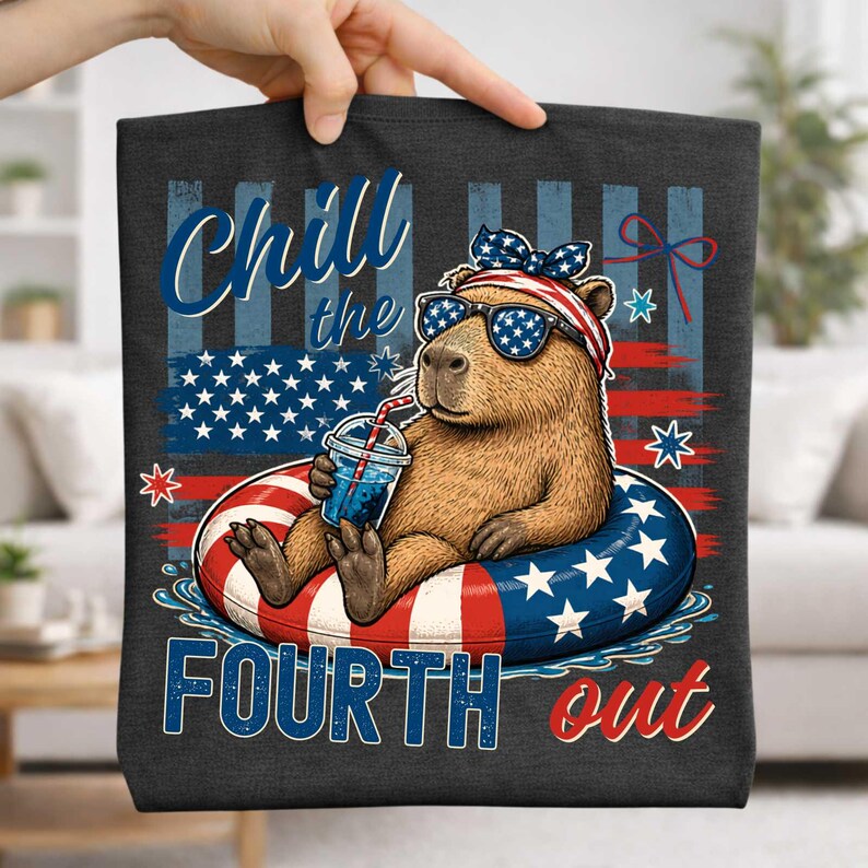 May include: Dark gray tote bag featuring a capybara wearing sunglasses and a patriotic headband, floating in a red, white, and blue inner tube. The bag has the text "Chill the Fourth out" and an American flag design.