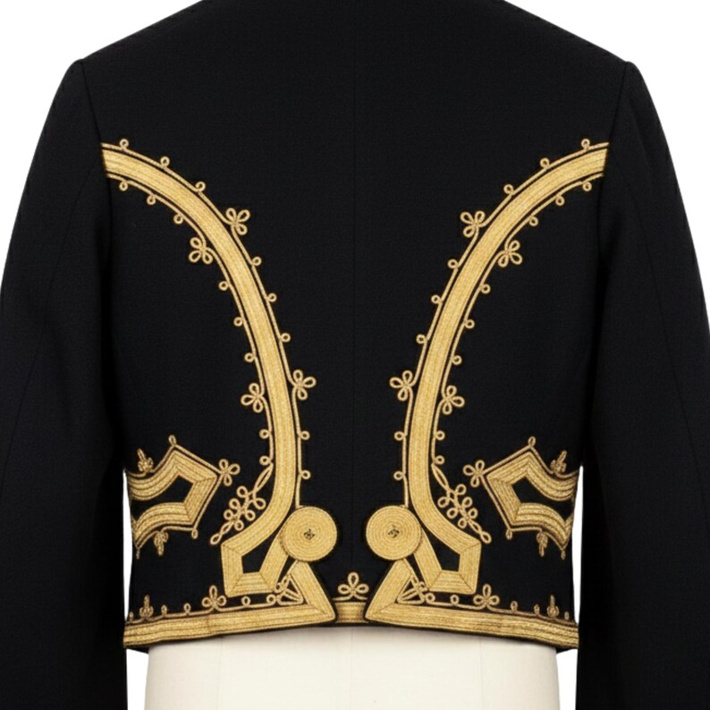 May include: Black jacket with gold embroidery. The jacket features ornate gold floral embroidery along the edges and back, creating a striking contrast against the dark fabric. The design includes intricate patterns and shapes.