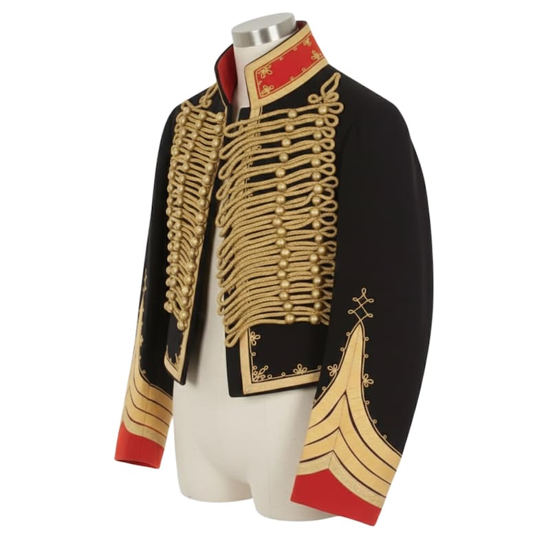 May include: Black military-style jacket with gold rope detailing and gold embroidery. The jacket features a red collar and red cuffs. The jacket is displayed on a mannequin.