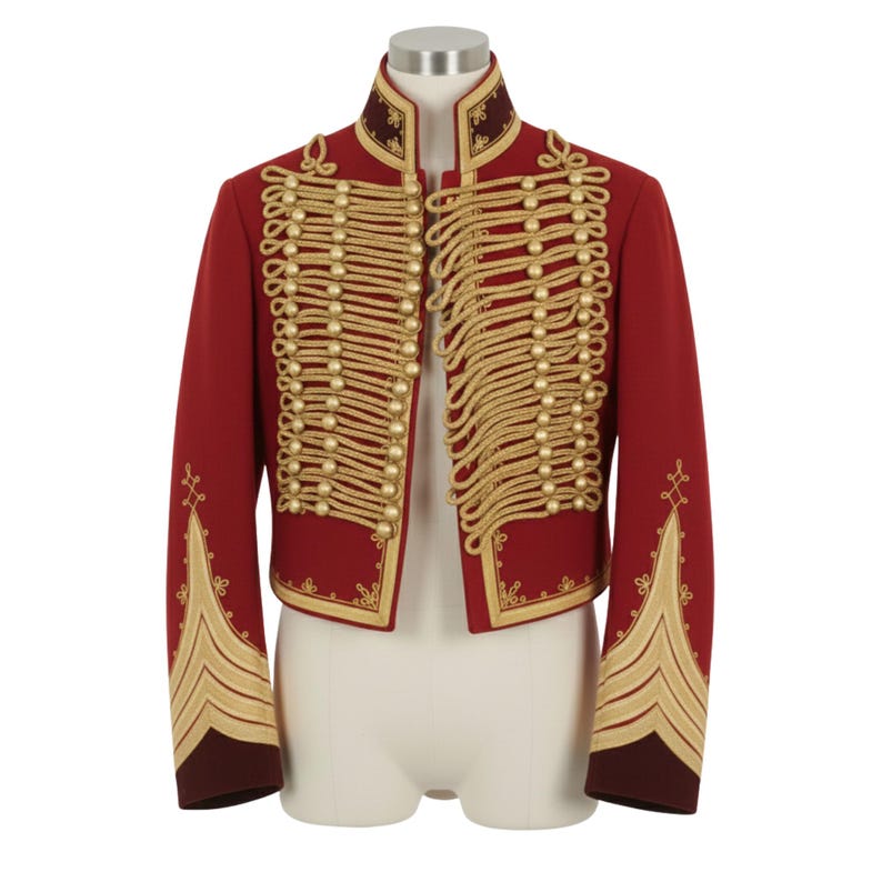 May include: A red military-style jacket with gold-colored rope detailing and gold buttons. The jacket has a high collar and gold embroidery on the sleeves and edges. The jacket is displayed on a mannequin.