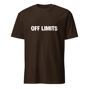 May include: A brown t-shirt with the words "OFF LIMITS" printed in white across the chest. The shirt has short sleeves and a crew neck.