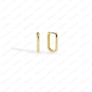 May include: A pair of gold-colored rectangular hoop earrings. The earrings have a simple, polished design and a secure clasp. The earrings are displayed against a white background.