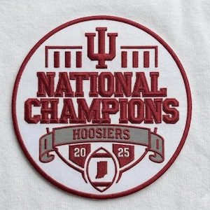 May include: A circular embroidered patch with a white background and a maroon border. The patch features the words "NATIONAL CHAMPIONS" in maroon, along with the word "HOOSIERS" and the years "20" and "25". An outline of the state of Indiana is also present.