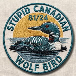 May include: Embroidered patch with a teal border and the words "STUPID CANADIAN WOLF BIRD." The design features a loon in water, a yellow sun, and the numbers "81/24."