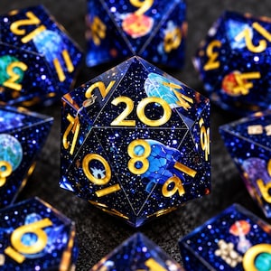 May include: A set of polyhedral dice made from dark blue translucent resin with embedded glitter and gold-colored numbers. Each die features small, colorful illustrations of various sea creatures, including jellyfish and turtles, suspended within the deep blue material.