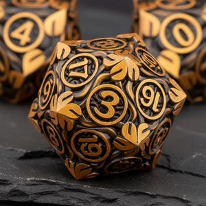 May include: A bronze-coloured, twenty-sided die with gold-coloured numbers and leaf-like designs. The die is set against a dark background, with other dice visible in the background. The numbers are in a circular font.