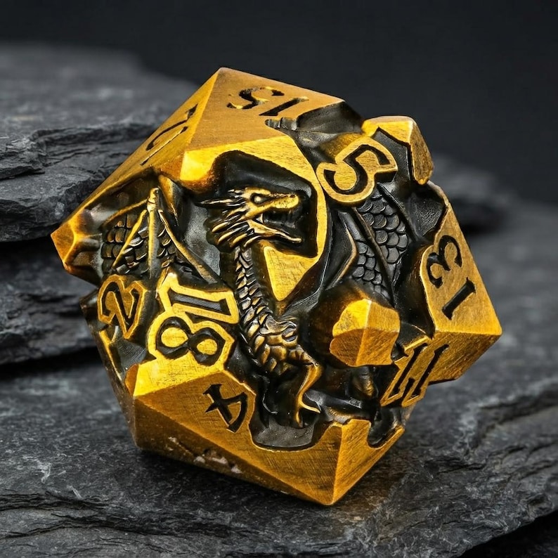 May include: A twenty-sided die featuring a metallic gold finish with black recessed areas. The surface is intricately sculpted with a dragon motif, and the numbers are engraved in a bold, black font across the various triangular faces.