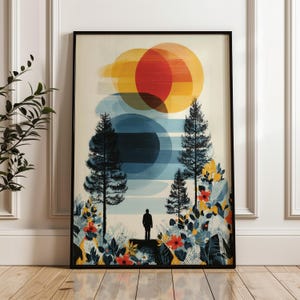 May include: Framed art print featuring a landscape scene with overlapping circles in shades of yellow, orange, and blue. Silhouetted trees and a figure stand in front of a floral foreground. The artwork is enclosed in a black frame.