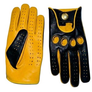 Könnte beinhalten: Ein Paar gelb-schwarze Fahrhandschuhe. Die Handschuhe sind aus Leder gefertigt und verfügen über ein perforiertes Design für Atmungsaktivität. Die Handschuhe haben schwarze Akzente an den Knöcheln und einen Druckknopfverschluss.