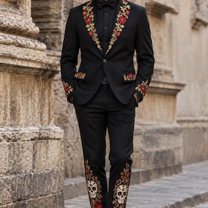 Può includere: Un abito nero con intricati ricami floreali rossi e dorati sui revers, sui polsini e sulle patte delle tasche. I pantaloni presentano dettagliati ricami di teschi e fiori. Un cappello nero abbinato con un fiore rosso e trucco da teschio.