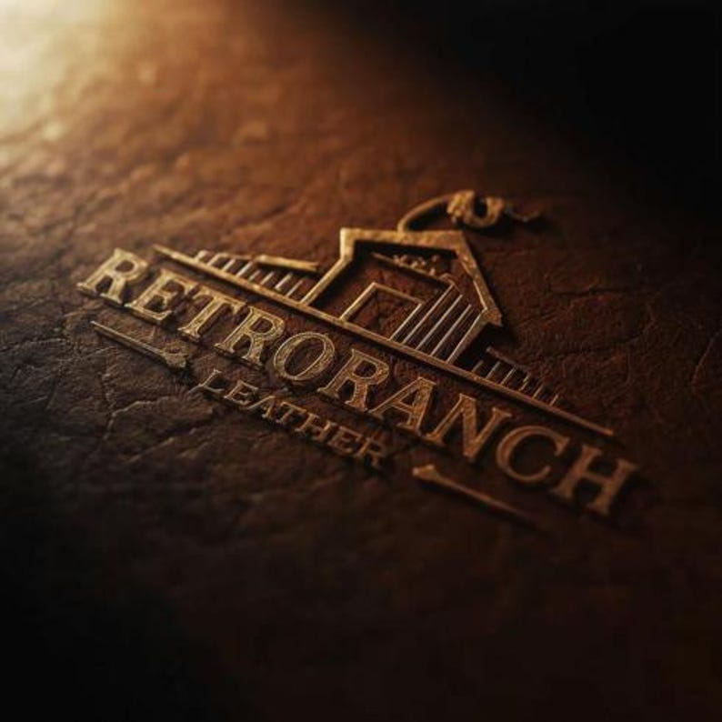 K&ouml;nnte beinhalten: Nahaufnahme einer braunen Lederoberfl&auml;che mit dem gepr&auml;gten Text "RETRO RANCH LEATHER" in Gold. Das Logo zeigt ein Ranchgeb&auml;ude und einen Lasso, was ein Western- oder rustikales Thema suggeriert.