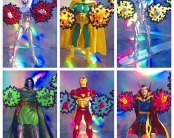 May include: Six action figures of Marvel comic characters, including Ultron, Vision, Silver Surfer, Doctor Doom, Iron Man, and Doctor Strange. Each figure is posed with a colorful, spherical energy effect emanating from their hands.