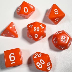 May include: Set of seven orange polyhedral dice for tabletop games. Each die has white numbers, including a D4, D6, D8, D10, D12, D20, and a D00/D%. The dice are arranged on a white surface.