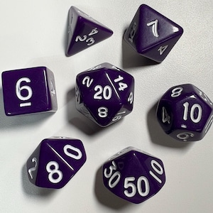 Puede incluir: Conjunto de siete dados poliédricos morados con números blancos. El conjunto incluye un dado de cuatro caras, un dado de seis caras, un dado de ocho caras, un dado de diez caras, un dado de doce caras, un dado de veinte caras y un dado de porcentaje. Para juegos de rol.