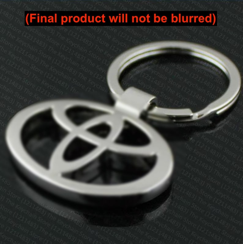 May include: Silver-colored Toyota logo keychain. The keychain features the Toyota emblem in an oval shape with a key ring attached. The design is simple and modern, suitable for car enthusiasts.