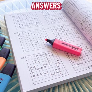 K&ouml;nnte beinhalten: Ein offenes Buch mit japanischen Schriftzeichen und ein pinkfarbener Stabilo Boss Textmarker. Das Wort "ANSWERS" steht oben. Mehrere weitere Textmarker in Gelb, Gr&uuml;n, Orange und Blau sind sichtbar.