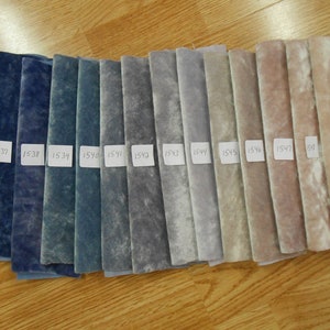 Puede incluir: Una colección de 14 muestras de tela en varios tonos de azul, gris y beige. Las muestras están etiquetadas con números del 1536 al 1549.