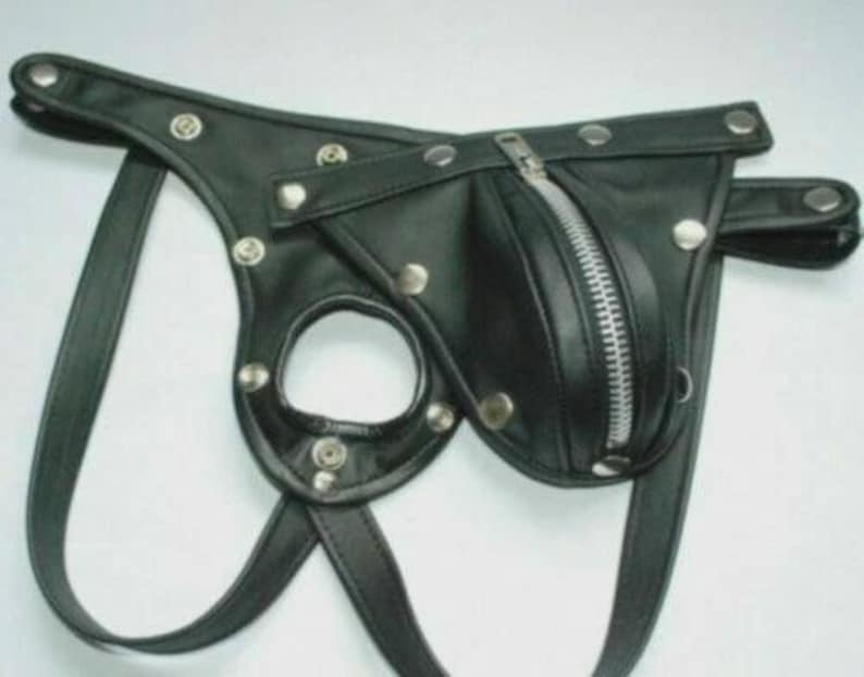 May include: Black leather jockstrap with a zippered pouch and silver-tone metal rivets. The jockstrap features a circular opening and adjustable straps. The design includes a zipper closure and is made of a smooth, shiny material.