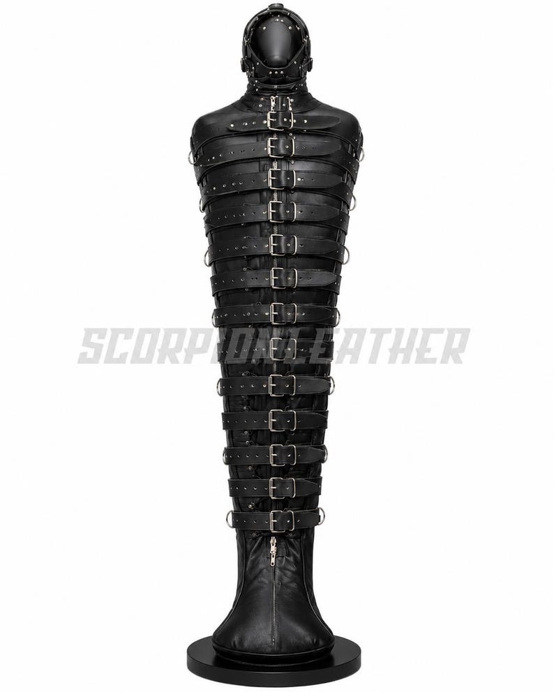 May include: A black leather straightjacket-style body bag featuring a full-head hood with eye and mouth openings, secured by numerous horizontal straps with silver-toned metal buckles and D-rings. The text SCORPION LEATHER is visible in the center.