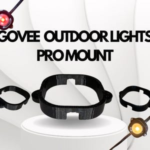 May include: Black PRO MOUNT for Govee outdoor lights. The image shows a large circular mount and two smaller mounts. The text "GOVEE OUTDOOR LIGHTS PRO MOUNT" is displayed in large, bold, black letters.