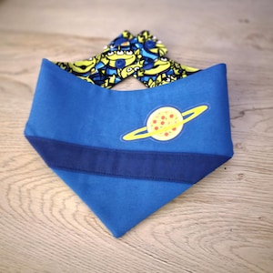 May include: Blue dog bandana with a dark blue stripe and a yellow planet graphic. The top of the bandana features a pattern of green and blue cartoon aliens.