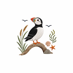 Puede incluir: Un diseño bordado que muestra un frailecillo con pico negro, blanco y naranja posado sobre una rama marrón curvada. La escena incluye juncos verdes, una concha rosa, una estrella de mar naranja, una roca gris y dos pequeñas aves negras volando.