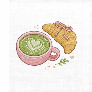 Puede incluir: Un diseño de bordado que muestra una taza rosa llena de matcha latte verde con arte en forma de corazón, acompañado de un croissant dorado atado con un lazo rosa, decorado con pequeños corazones rosas y una pequeña rama de hojas verdes.
