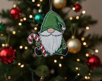 May include: A Christmas tree ornament featuring a green gnome with a white beard and a candy cane. The gnome is wearing a green hat and holding a red and white striped candy cane. The ornament is hanging on a Christmas tree with red and gold ornaments.