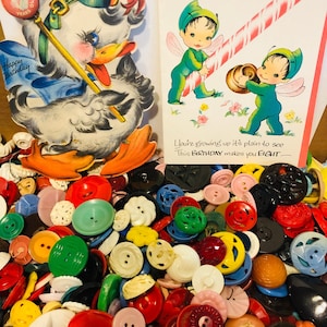 May include: A large collection of colorful buttons in various shapes and sizes. The buttons are made of plastic, metal, and wood. Some of the buttons have two holes, while others have four holes. The buttons are arranged in a random pattern.