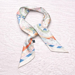 May include: A colorful silk scarf with a geometric and floral pattern in pastel shades of pink, blue, orange, and green. The scarf is tied in a knot, showcasing its intricate design and delicate fabric.
