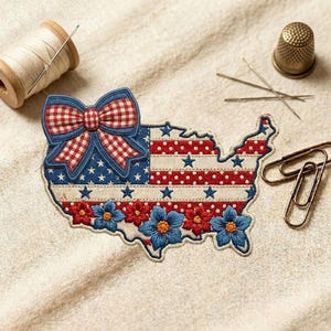 May include: Embroidered patch in the shape of the United States, featuring a bow, stars, and flowers in red, white, and blue. The patch is surrounded by sewing notions, including a spool of thread, needles, a thimble, and paper clips.