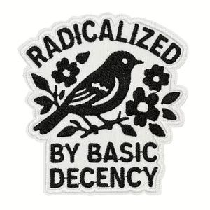 May include: Embroidered patch with a black bird perched on a branch, surrounded by flowers. The text "RADICALIZED" arches above the bird, and "BY BASIC DECENCY" is below. The patch has a white background and a scalloped border.