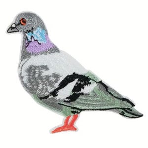 May include: Embroidered patch of a pigeon. The bird features a gray head, a light blue and purple neck, and a white and gray body. The wings are green and black, and the feet are orange. The patch is designed to be ironed on or sewn.