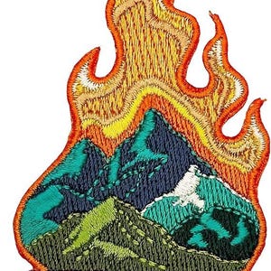 May include: Embroidered patch featuring a campfire scene. The design includes flames in shades of orange and yellow, mountains in blue, green, and white, and a brown log base. The patch is likely for clothing or accessories.