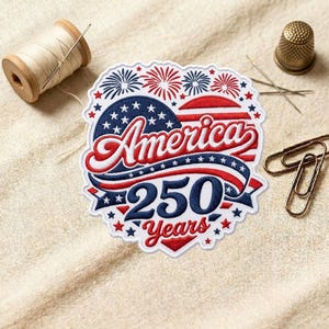 May include: Embroidered patch with the text "America 250 Years" in red, white, and blue. The design includes stars, stripes, and fireworks. A spool of thread, needle, thimble, and paper clips are also visible.