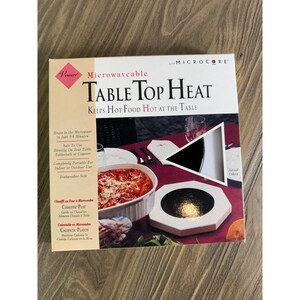 May include: A square product box for a microwavable Table Top Heat warming pad. The packaging features text including "Microwaveable Table Top Heat" and "Keeps Hot Food Hot at the Table," with an image of a white octagonal warming pad.