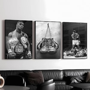 Può includere: Set di tre stampe incorniciate in bianco e nero a tema boxe. Una raffigura un pugile con cinture da campione, un'altra mostra guantoni da boxe appesi e la terza un pugile in piedi su un avversario sconfitto sul ring.