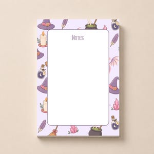 May include: A rectangular notepad with a light purple border featuring a repeating pattern of witch hats, candles, potion bottles, feathers, crystals, and cauldrons. The centre of the page is white with the word NOTES printed at the top.