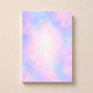 May include: A rectangular notepad featuring a soft pastel gradient of pink, purple, and blue colors. The design includes a scattered pattern of tiny white stars and small, round, solid-colored spheres in shades of pink, blue, and yellow.