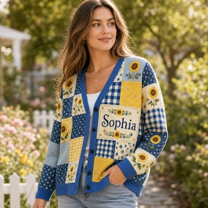 May include: A long-sleeve button-down cardigan featuring a patchwork design of blue and yellow sunflower patterns, blue and white gingham checks, and small floral prints. The front panel displays the name Sophia in dark blue script lettering.